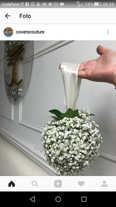 someone is holding a vase with flowers in it