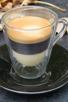 a glass cup filled with liquid sitting on top of a saucer