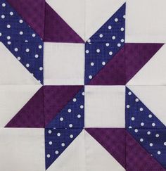 a purple and white quilted star with polka dots on the center is featured in this close up photo