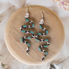 three pairs of earrings sitting on top of a wooden table