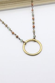 This Circle Pendant Necklace with Assorted Beads is the perfect way to add a touch of subtle elegance to your look. Its simple yet intricate circle design is sure to add a unique and stylish flair, making it perfect for any occasion. The assorted beads add a unique touch to this elegant piece, making it an ideal addition to any jewelry box.Details: Circle Pendant Handmade Stone Bead Necklace Lobster Claw Clasp Approximate Dimensions: Length: 17.0" Extension: 1.5" Circle Pendent: 1.13" x 1.13" Be Bohemian Round Necklace For Everyday Wear, Bohemian Round Necklace For Everyday, Everyday Bohemian Round Necklace, Bohemian Everyday Round Necklace, Adjustable Round Minimalist Beaded Necklace, Minimalist Adjustable Round Beaded Necklaces, Everyday Circular Brass Necklace, Everyday Brass Necklace, Minimalist Adjustable Round Beaded Necklace