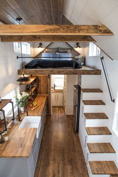 the interior of a tiny home with stairs leading up to the loft and kitchen area