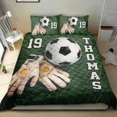 a bed with two soccer gloves and a ball on it