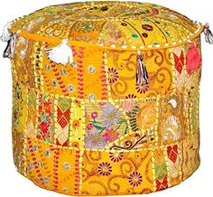 a yellow patchwork ottoman with tassels and beads on it's sides