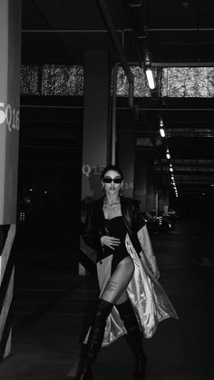 black and white photograph of woman in sunglasses posing for the camera with her hand on her hip