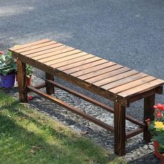 a wooden bench sitting next to potted plants