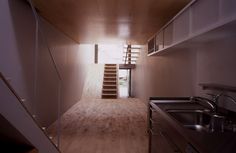 an empty kitchen with stairs leading up to the second floor and another room on the other side