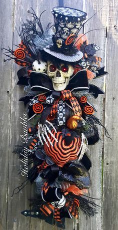 an assortment of halloween decorations hanging on a wooden fence