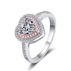 a heart shaped diamond ring with pink and white diamonds on the band, set in 18k white gold