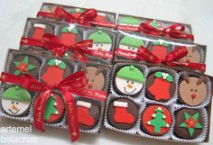 several decorated chocolates in boxes with red bows and snowman decorations on the top