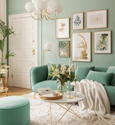 a living room with green walls and pictures on the wall above the couch, coffee table