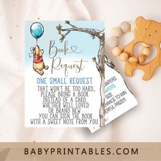 a winnie the pooh baby shower sign next to a teddy bear and wooden rattler