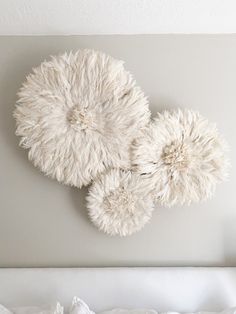 three white fluffy balls hanging on the wall