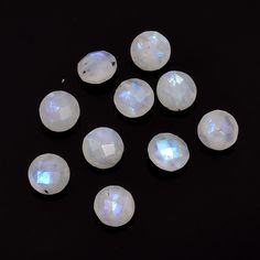 seven white opalite stones arranged on a black surface