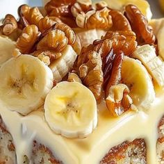 a cake with bananas, walnuts and pecans on top is covered in icing