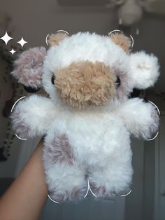 a teddy bear is being held up by someone's hand with stars above it