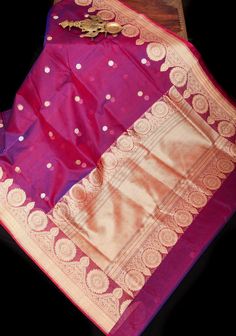 ChatG This Red and Blue Dual Tone Gorgeous Pure Banarasi Kora Silk Saree is a celebration of exquisite craftsmanship and timeless beauty. Woven from luxurious Kora silk, renowned for its delicate texture and graceful drape, this saree embodies the essence of traditional elegance. The dual-tone effect, blending vibrant red and regal blue hues, creates a captivating visual appeal that effortlessly commands attention. This harmonious interplay of colors adds depth and dimension to the saree, enhancing its allure with every fold. Adorning the saree are Sona Rupa Floral Buttas, meticulously woven throughout the fabric. These golden floral motifs, inspired by nature's beauty, infuse the saree with a sense of opulence and grandeur, reminiscent of royalty. Whether draped for a wedding celebration Bollywood Style Handloom Lehenga For Celebrations, Handloom Lehenga For Diwali Celebration, Diwali Celebration Handloom Lehenga, Tussar Silk Traditional Wear With Pallu For Celebration, Paithani Silk Lehenga With Pallu For Celebration, Celebration Paithani Silk Lehenga With Pallu, Festival Handloom Lehenga For Celebration, Festival Celebration Handloom Lehenga, Paithani Silk Lehenga With Zari Weaving For Celebration