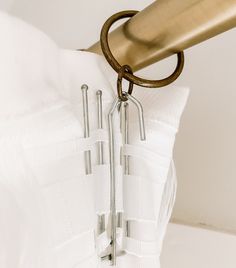 a white dress with metal hooks hanging from it's front and back zippers