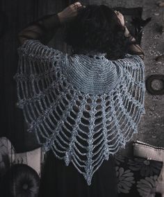 a woman wearing a blue crochet shawl