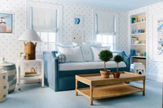 a living room with blue and white decor on the walls, couches and coffee table