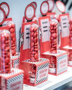 red candy candies are on display in glass cases with gas signs and numbers around them