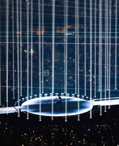 a man standing on top of a stage surrounded by lights