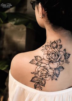 a woman with a flower tattoo on her back shoulder