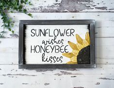 a wooden sign that says sunflower wishes honeybee kisses on the side of a wall