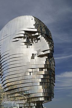 a tall building with a face on it's side in front of a blue sky