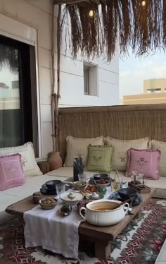 a table with food on top of it in front of a couch and some windows