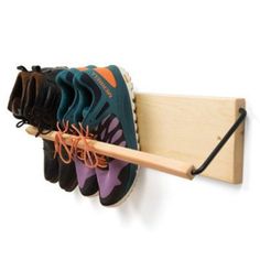 a pair of shoes hanging from a wooden shoe rack