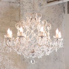 a chandelier hanging from the ceiling in a room with peeling paint on the walls