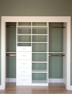 an empty walk in closet with white shelves and drawers on each side, against the wall