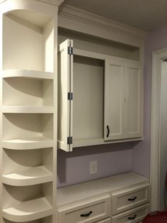 an empty closet with white cabinets and drawers