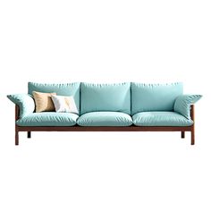 a blue couch with two pillows on it and a white wall in the back ground