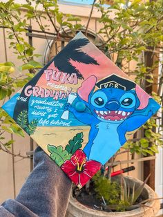 a person holding up a book with an image of stitch on it's cover