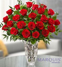 a vase filled with red roses on top of a table