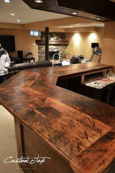 a man standing in front of a wooden counter top next to a couch and chair