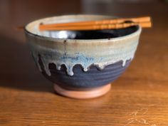 a bowl with chopsticks in it sitting on a table