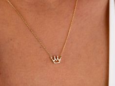 "The 14K Gold Crown Necklace is a delicate and dainty piece of jewelry that is perfect for any princess in your life. It features a tiny solid gold crown pendant that is delicate and feminine, making it a perfect choice for those who prefer subtle and understated jewelry. This necklace is made from 14K gold, which is a high-quality and valuable metal that is resistant to tarnish and wear. It is the perfect gift for any special occasion, whether it be for Christmas, Father's Day, Mother's Day, Va 14k Gold Crown Design Jewelry As A Gift, Dainty Jewelry With Crown Design For Gift, 14k Gold Jewelry With Crown Design For Gift, Dainty Jewelry With Crown Design As Gift, Understated Jewelry, Crown Pendant Necklace, Mini Crown, Crown Pendant, Princess Necklace