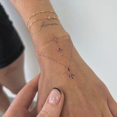 two people holding hands with tattoos on their wrists and wrist, one has a star tattoo on the other hand