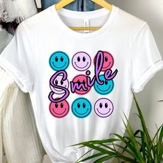 "These soft & comfy Bella Canvas t-shirts are sure to be your new \"must have more\" shirts! Emoji tshirt, Smiley Face shirt, Womens smiley tshirt, Womens Summer shirt, Womens Summer tshirt, Gift for her, Womens gift, Gift for women, Gram gift, Grandmother gift, Gardening tshirt, Mother's Day gift Recommendations: *For a standard fit, stick with your typical size *For an oversized fit, size up *For a fitted shirt, size down. *Shirts are longer. Great for knots, Tucks, or nice coverage with leggings. *Unisex Cut. works great for Everyone! Women sizes: Small: 2-4 | Medium: 6-8 | Large: 10-12 | XL: 14-16 | 2XL: 18-20 | 3XL: 22-24 | 4XL: 26-28 Men sizes: Select your standard size. Details: *Soft, Breathable, & very comfy Bella + Canvas *Pre-shrunk fabric *Solid Colors: 100% combed and ring-spu Emoji Tshirt, Smiley Face Tshirt, Smiley Face Shirt, Grandmother Gifts, Tees For Women, Smiley Face, Summer Tshirts, Summer Shirts, Smiley