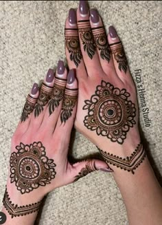 two hands with henna tattoos on them