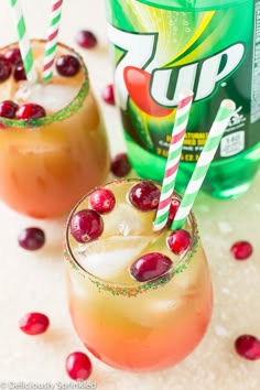 two glasses filled with liquid and topped with candy canes next to a can of up soda