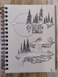 a notebook with a drawing of a waterfall and trees on the cover, next to a pen