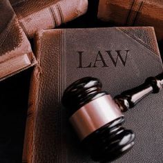 a law book with a judge's gavel on it and other law books in the background