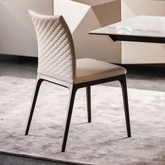 a modern dining table and chair set with white upholstered fabric on the back