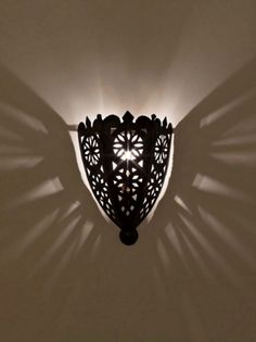 an intricately designed light fixture casts a shadow on the wall