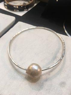 Argentium 12 gauge Sterling silver soldered with a 18-20 mm barogue pearl. Shipped with a gift card in a gift box! Specify size wrist 6,7,8 as well as a square shape Bangle. The benefit of Argentium is purity of the Sterling without the copper, will not tarnish! Silver Bangle Bracelet With Pearl Charm, Pearl Bangle Jewelry Gift, Pearl Drop Bangle Bracelet For Gift, Pearl Bangle Jewelry As Gift, Silver Pearl Bracelet With Pearl Drop As Gift, Silver Pearl Bracelet With Pearl Drop For Gift, Silver Pearl Drop Bracelet As Gift, Handmade Silver Pearl Bracelet Gift, Silver Pearl Drop Bracelet With Round Shape