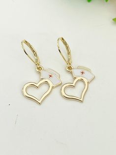 "This is gold or silver tone Heart Nurse Cap charm on stainless teel hypoallergenic ear hook. ♥ You will receive 1 pair. HOW TO ORDER 1) Select the quantity. 2) Select finish 3) Add to cart. DESCRIPTION ♥ 304 Stainless Steel Leverback Earring Findings, Real 24K Gold Plated, Size: about 0.65 inch(16.5mm) long, 0.39 inch(10mm) wide, 0.08 inch(2mm) thick, pin: 0.04 inch(1mm)., Lead & Nickel Safe ♥ Heart Nurse Cap, Zinc Based Alloy Charms, Gold Plated Enamel, Size: 20mm (6/8\") x 15mm (5/8\"), Lead & Nickel Safe PLEASE READ: ♥ We are happy to help with any situation so please reach out with any concerns. ♥ Materials from the USA and international sourcing. ♥ I do not include invoices in any packages unless requested. ♥ Made to order, please allow 2-5 days for us to make your item before shippi Nursing Earrings, Medical Earrings, 14k Gold Tarnish-resistant Earrings For Valentine's Day, Nurse Jewelry Nursingpin, Nickel-free Gold Heart Brass Earrings, Nursing Student Gifts, Nursing Cap, Leverback Earrings, Jewelry Card